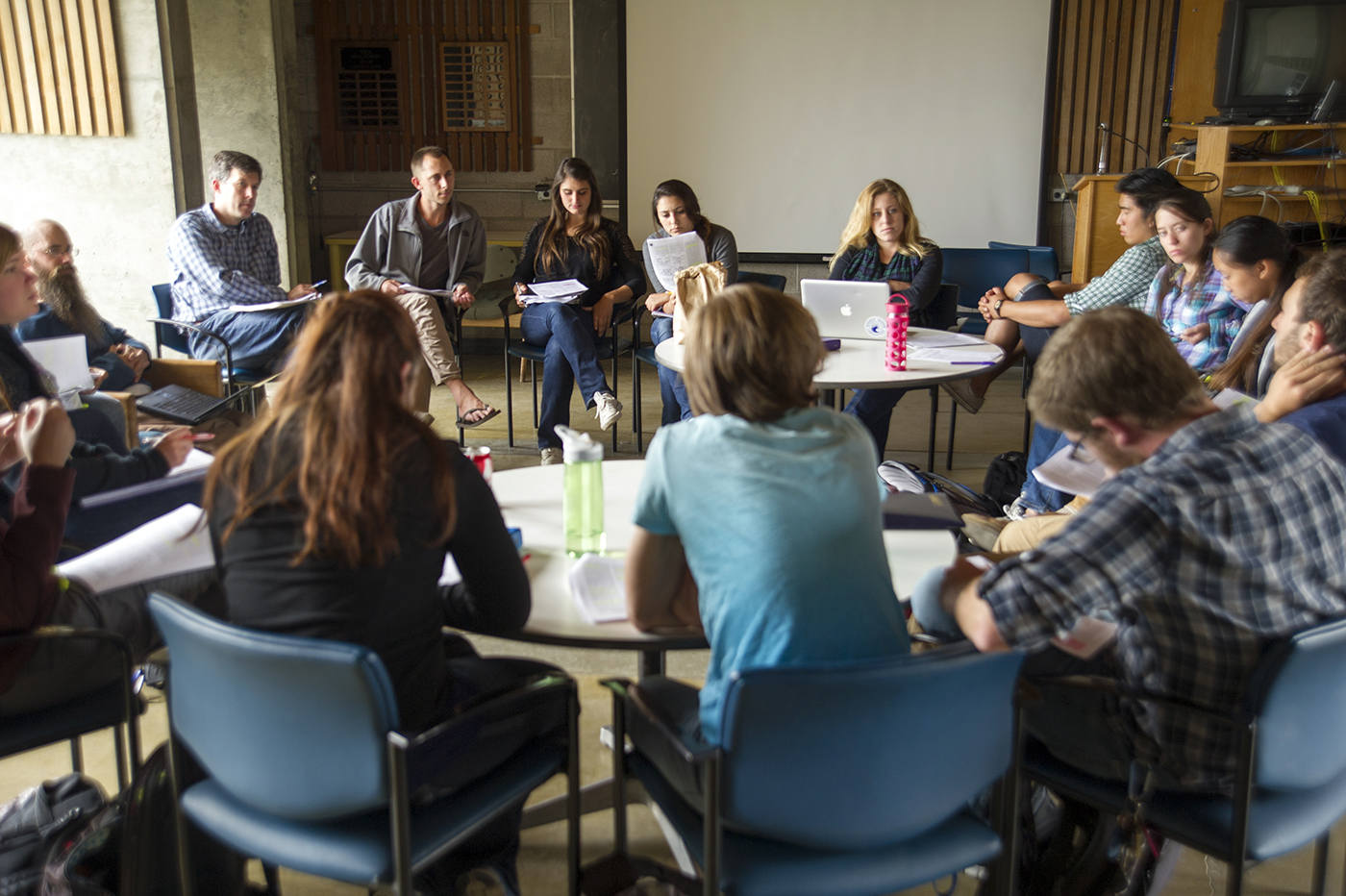 A large group of students seated in a circle during a class discussion.