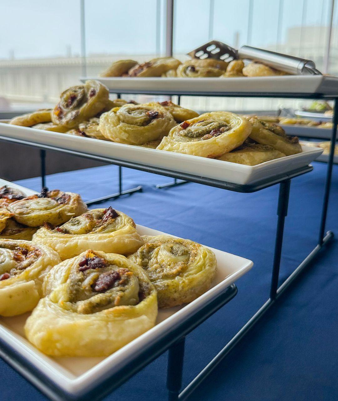 A catering display with rolled pastries set on a blue tablecloth