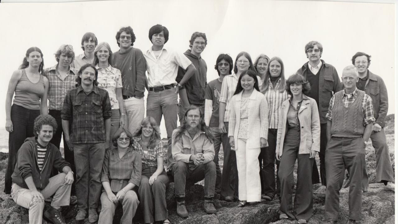 A black-and-white photo of a group of students standing on the rocks near BML.