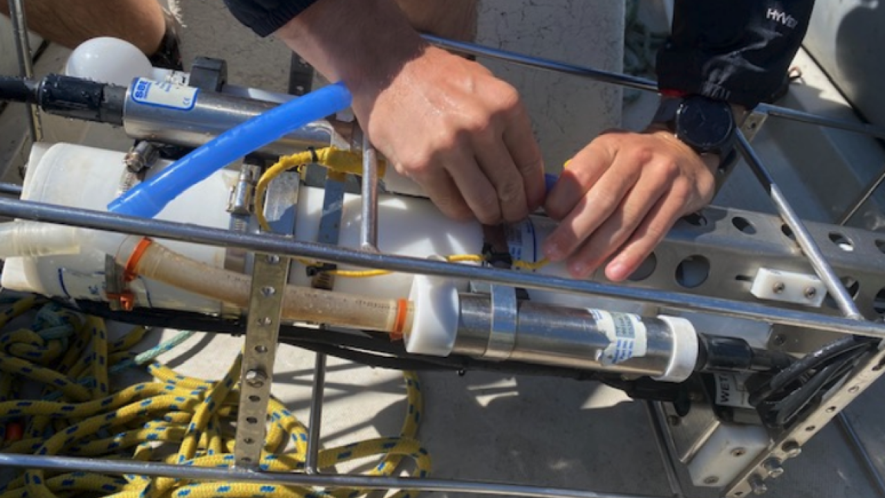 A close up of a pair of hands working on a piece of scientific equipment