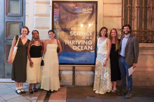A ground of dressed up people standing in front of a sign that reads "Science for a Thriving Ocean" at the Nice Opera House