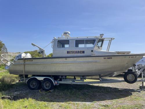 A side view of a silvery boat that says "research" on the side
