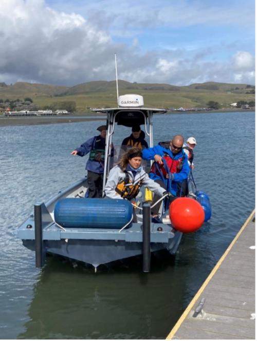 A group of people on a boat, just pulling away from the dock