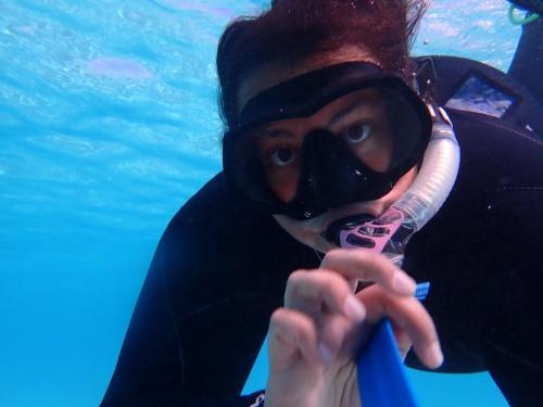 Anya Brown looks at the camera through her snorkel mask as she swims in the ocean.