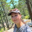 A portrait of Ana Roden standing in front of a redwood forest