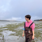 Lucas Hernandez wearing waders and walking in a mudflat