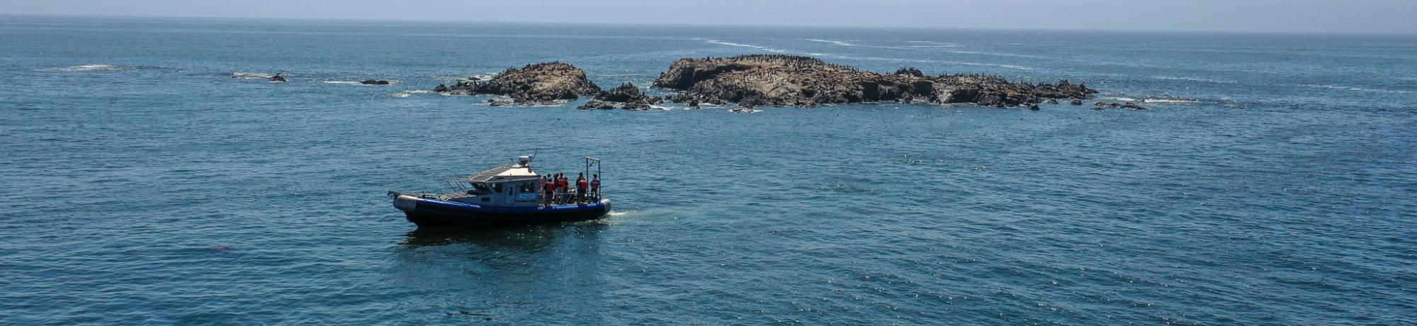 A boat out on serene waters with a small landmass behind it